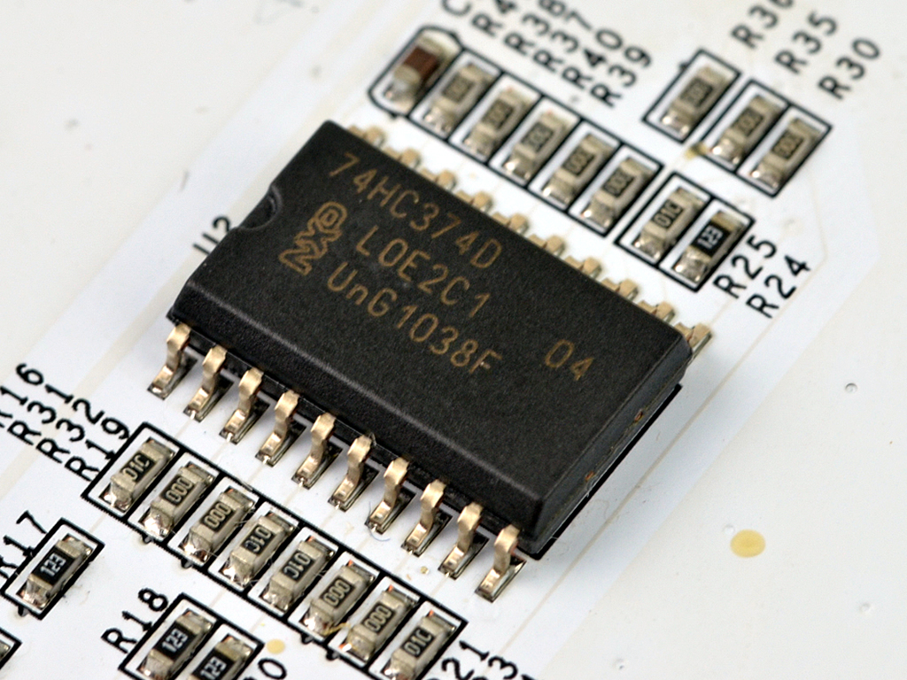 「OC PANEL」背面の基板上に実装されている、NXP Semiconductors製フリップフロップ「74HC374D」。このチップがトグルスイッチの配置を読み取り、カード側に伝えてくれる